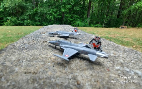 Customer's two Herpa Swiss Air Force F5E models lined up on a stone wall outdoors.