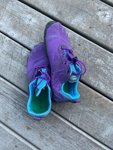 Customer's purple and blue Free I - Barefoot Shoes sitting on a wooden surface.