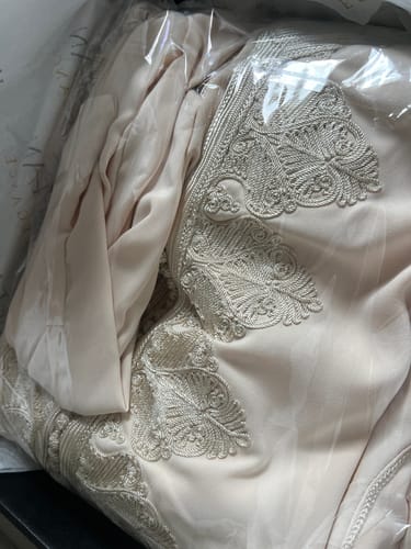 Close-up from a customer of the Caftan Hind in its packaging, showing the beautiful and intricate embroidery.