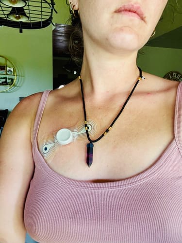 Reviewer wearing the Natural Fluorite Necklace. The pointed pendant has dark purple and black colors.