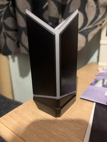 Customer's black and white BTS Official Light Stick Ver.4 Cradle standing on a wooden table.