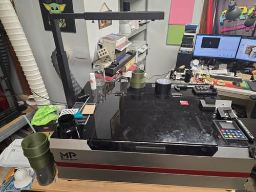 Reviewer's AtomStack AC2 Wireless Camera mounted above a large Monport laser engraving machine in a workshop.