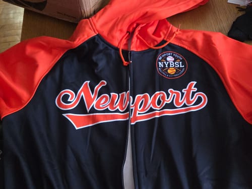 Reviewer's custom black and orange full-zip hoodie showing the stitched 'Newport' text and league patch.
