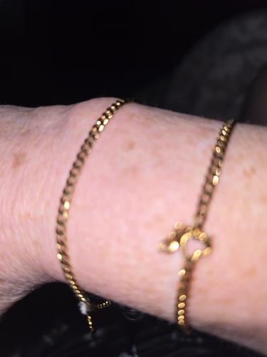 Customer's close-up of two gold Permanent Bracelets on their wrist.