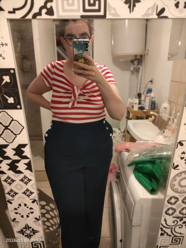 Cliente portant la combinaison patchwork avec un haut rayé rouge et blanc et un pantalon bleu.