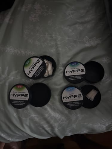 Customer showing four tins from their HYPPE Sample Pack, with two open to display the pouches inside.