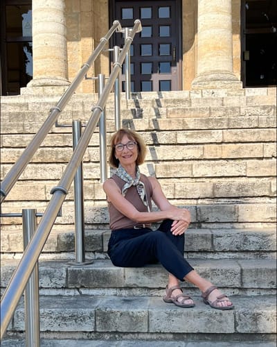 Customer wearing the sienna Raegan Ribbed Tank Top while sitting on outdoor stone steps.