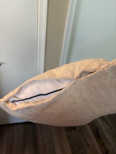 Customer's Mabel pillow cover with a broken zipper, revealing the white pillow insert.