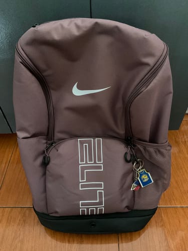 Customer's mauve Nike Varsity Elite Backpack shown upright from the front, displaying the white Nike swoosh and 'ELITE' text.