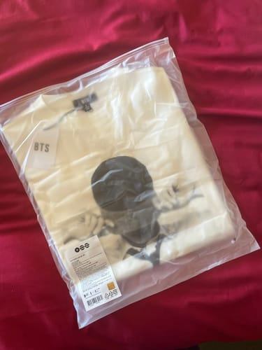 Customer's BTS Jin Arirang t-shirt, still folded and sealed in its official plastic packaging.