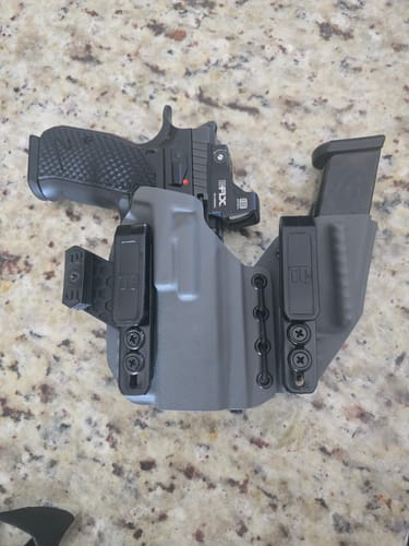 Customer's gray AXIS ELITE holster holding a handgun and a magazine on a countertop.