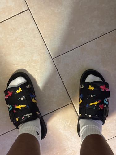 Reviewer wearing the colorful Cross Patch Dracoslides with white socks.