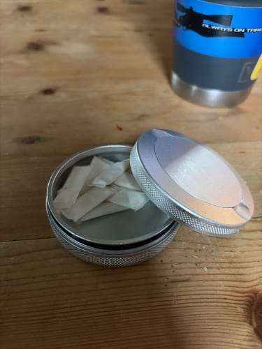 Customer's HYPPE Moist Pouches in a round silver tin on a wooden table.