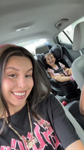 A smiling customer in a car wearing the dramatic Manga - Brown lash extensions.