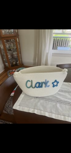 Customer's white Baby Knits basket personalized with the name 'Clark' and a blue star icon.