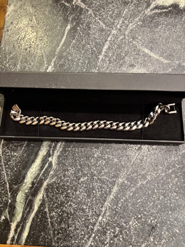 Reviewer's silver Trident Bracelet displayed in its black presentation box on a marbled surface.