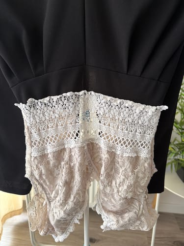 Gros plan par une cliente de la combinaison CECILE montrant la dentelle blanche déteinte par le tissu noir.
