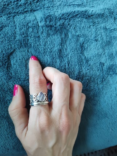 Reviewer's hand wearing the Sterling Silver Spinner Teardrop Moonstone Ring against a teal background.