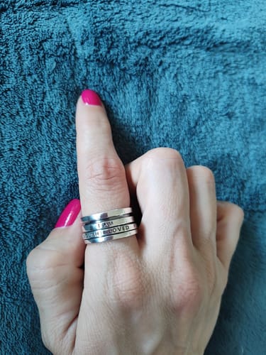 Reviewer's hand wearing the wide sterling silver Fidget Ring, showing the 'I AM' and 'LOVED' engravings.