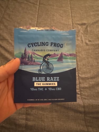 Reviewer holding the opened blue pouch of Blue Razz THC + CBD Gummies.