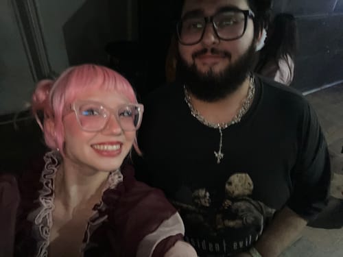 Reviewer wearing the silver ROTTEN ROSARY necklace in a photo with another person.