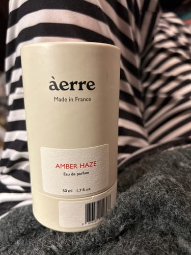 Customer's Amber Haze perfume in its cylindrical cream-colored packaging.