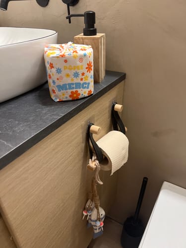 Le Papier Toilette Édition DÉCO d'un client dans son emballage floral, posé sur un comptoir de salle de bain.