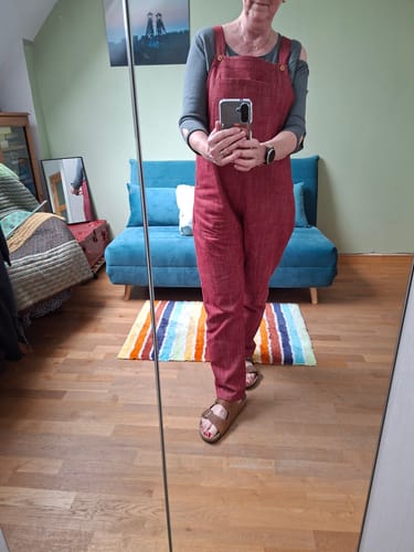 Cliente se prenant en photo dans un miroir, portant la salopette Mariette grenat.