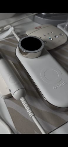 Close-up of the reviewer's white ONAIL Nail Drill Pro Max, showing the sleek control unit and handpiece.