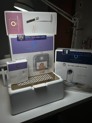 Reviewer's photo showing packaging for an AI nail lamp, nail drill, and other nail products on a desk.