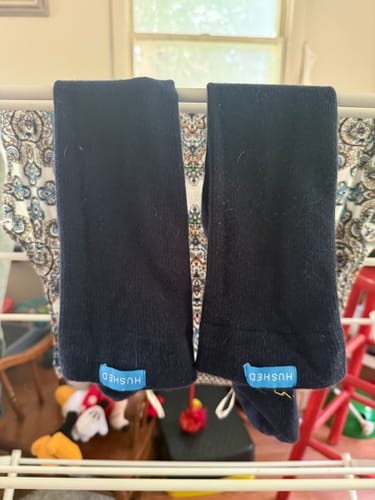 Customer's pair of black Eucalyptus Lyocell Compression Socks hanging over a drying rack.