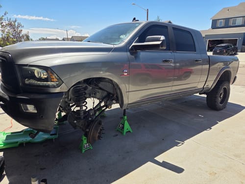 Customer's grey truck on jack stands with its front suspension exposed for work with the 9-106 Bushing Kit.