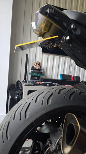 Customer's Master Hinge installed on a motorcycle, with the license plate holder flipped up horizontally under the tail light.