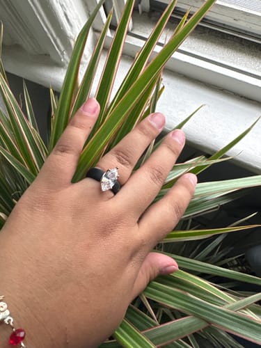 A customer's hand wearing the black Silicone Ring with a large marquise-cut CZ stone.