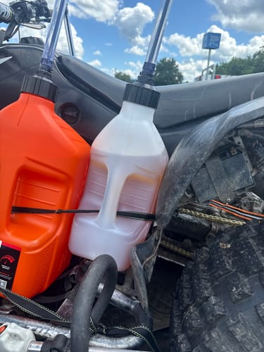 Customer's two 2.5 Gallon Jugs, one orange and one clear, strapped to the back of an ATV.