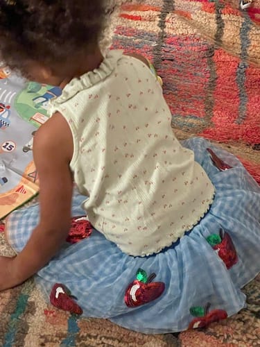 Customer's child wearing the blue Apple Sequin Tutu Skirt with red sequin apples.