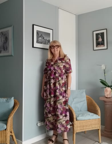 Cliente portant la Robe Édonie longue à imprimé aquarelle dans un salon.