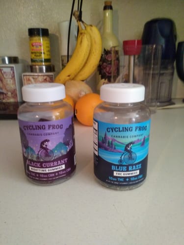 Reviewer's bottle of Blue Razz Gummies sitting on a counter next to the Black Currant nighttime gummies.