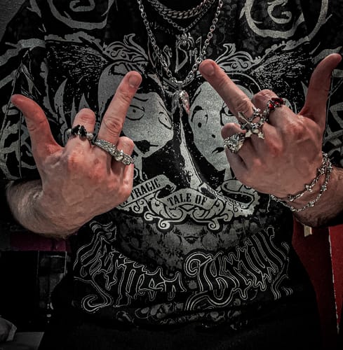Customer wearing a collection of silver jewelry, including a detailed Zodiac Pendant on a chain.