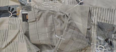 Customer's Silver Grey Box Checks formal pants folded inside their clear plastic packaging.