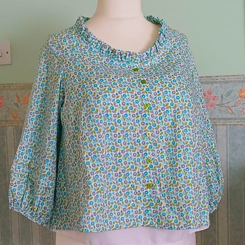 Customer's blouse made from the blue floral cotton lawn, with a ruffled collar and gathered sleeves.