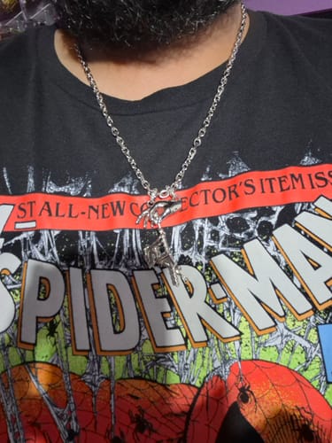 Close-up of a reviewer wearing the silver Aries Chain with a large pendant over a graphic t-shirt.