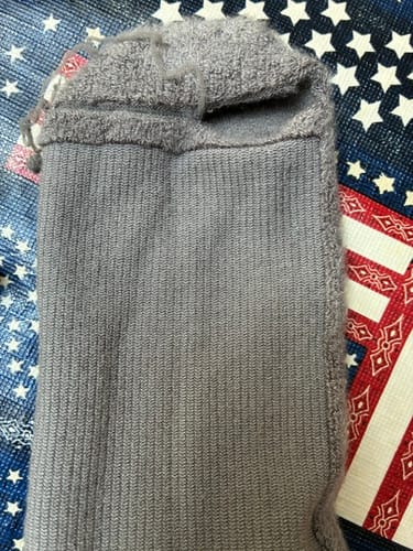 Customer's gray compression sock showing a frayed and worn top cuff.