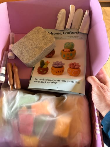 Customer unboxing the Craft DIY Subscription Box, revealing a complete needle felting kit with instructions.