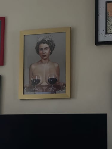 Customer's 'Majestic' art print of a topless woman with a crown, in a gold frame on a wall.