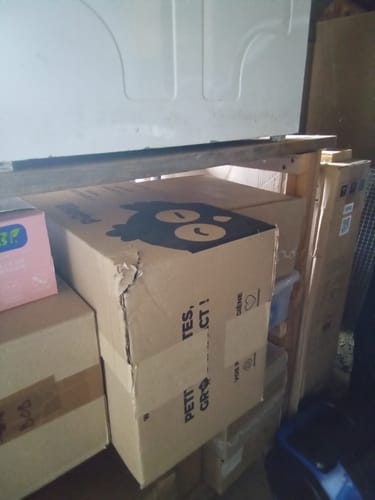 Photo d'un client du carton de livraison des boîtes mixtes, stocké dans un espace de rangement.
