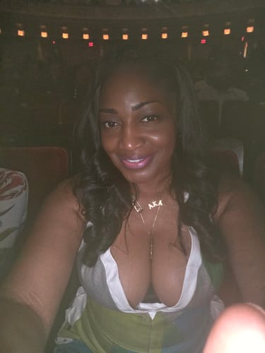 Close-up of a reviewer showing the deep V-neck of the loose sleeveless jumpsuit.
