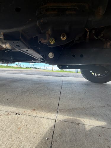 Customer's view from under a truck, showing the installed black Radius Arm Drop Bracket on the frame.