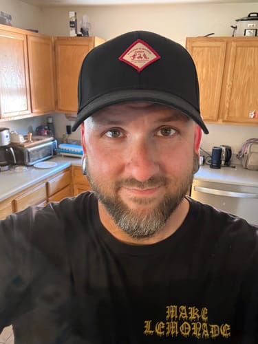 Reviewer showing the front fit of the black Big Structured Baseball Cap while wearing it indoors.
