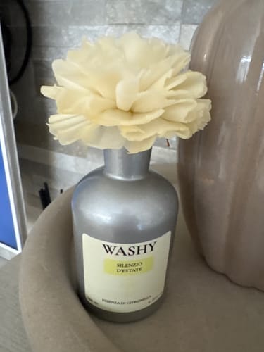 Cliente mostra il diffusore Silenzio d'Estate nel suo vaso argentato con il fiore che assorbe il profumo.